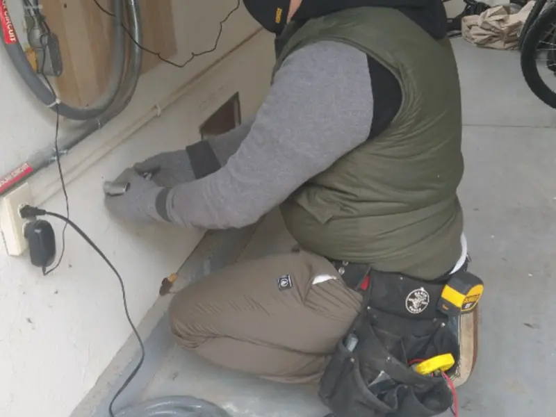 Electrician performing outlet wiring in a New Brighton garage